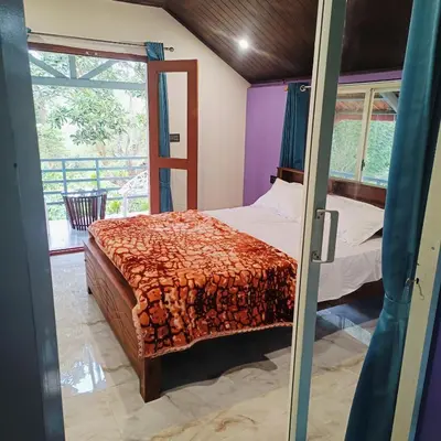 a bedroom with a bed and a window at Golden Valley Abode in Siddapur