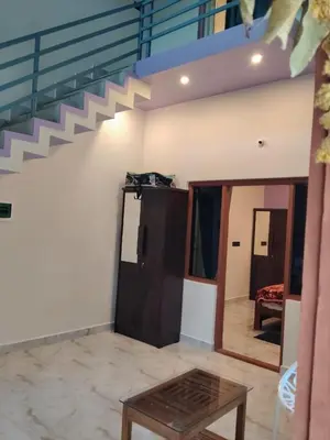 a living room with a staircase and a table at Golden Valley Abode in Siddapur