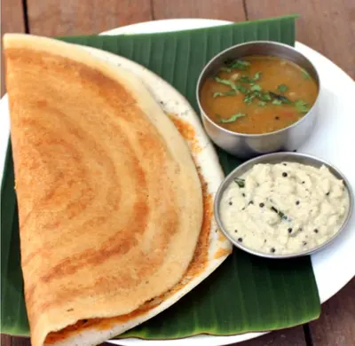 a plate of food with chapati and a bowl of dip at Puthooram Veedu in Kannur