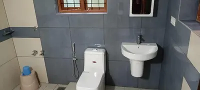 a bathroom with a toilet and a sink at Valley De Hills Villa Room in Attappādi