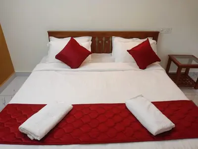 a bed with red and white pillows on it at Valley De Hills Villa Room in Attappādi