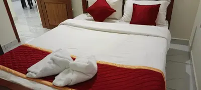 two twin beds with towels on a red blanket at Valley De Hills Villa Room in Attappādi