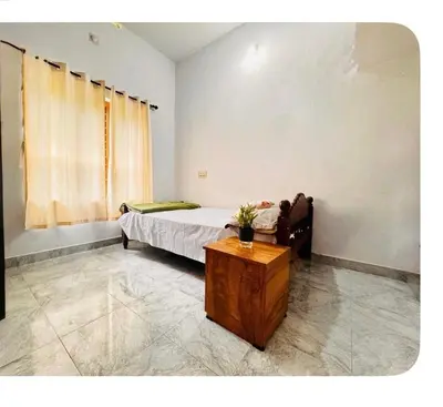 a bedroom with a bed and a table in it at Nirvana Stays Banasura -Lotus in Wayanad