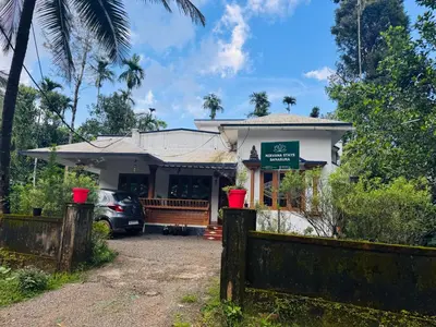 a house with a fence in front of it at Nirvana Stays Banasura -Lotus in Wayanad
