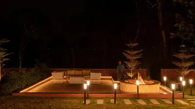 a person standing next to a fire pit at night at 1st Miracle By Mirth, Mythadi , Coorg in Ammatti