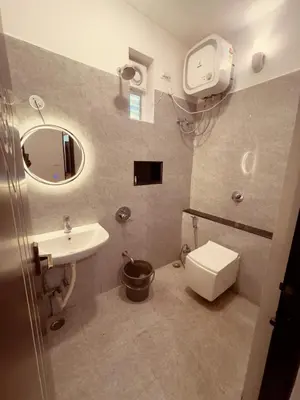 a bathroom with a sink and a toilet and a mirror at Vaj N Sat Villas in Kodaikānāl