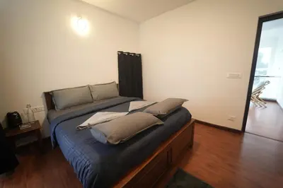 a bedroom with a bed with pillows on it at Vaj N Sat Villas in Kodaikānāl