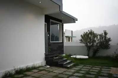 a house with stairs and a window on the side of it at Vaj N Sat Villas in Kodaikānāl