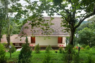 a small white house with a roof at Karlad Lake Resort in Wayanad