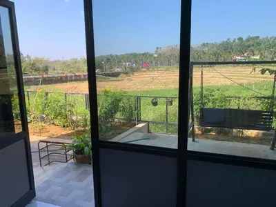 a view of a field from a window at Elysian in Mananthavady