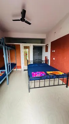 a bedroom with a bed and a ceiling fan at Campside Stays in Nāganahalli