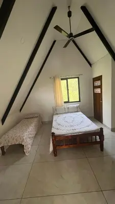 a bedroom with a bed and a window at Kacchi Kombu Castle By Calpavruksha Estate in Madikeri
