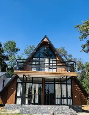 a house with large windows and a roof at Kacchi Kombu Castle By Calpavruksha Estate in Madikeri