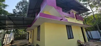 a house with a pink and yellow at JJ's Farmhouse in Thanniyam