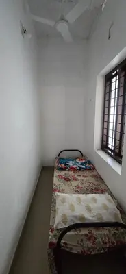 a small room with a bed in the corner at JJ's Farmhouse in Thanniyam