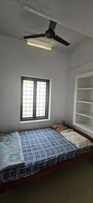 a bedroom with a bed and a ceiling fan at JJ's Farmhouse in Thanniyam