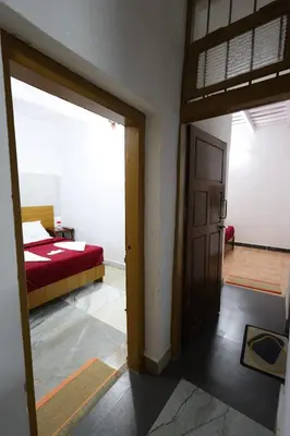 a room with a bedroom with a bed and a door at Vayuvana Heritage Organic Farm Resort in Panamaram