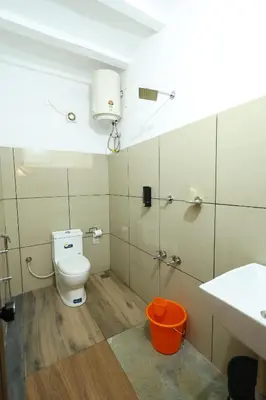 a bathroom with a toilet and a sink at Vayuvana Heritage Organic Farm Resort in Panamaram