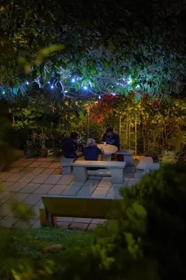 a group of people sitting at a picnic table at night at Girassol Serviced Villa in Vythiri