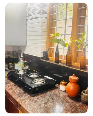 a stove top in a kitchen with a window at NirvanaStays-Blooms in Tariyod