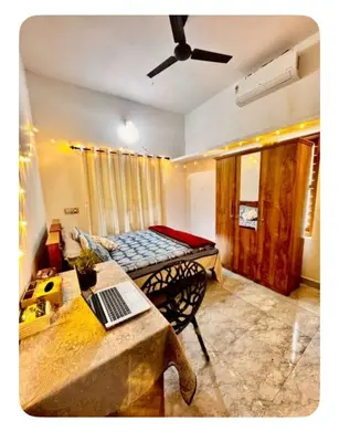 a room with a bed and a table with a laptop on it at NirvanaStays-Blooms in Tariyod