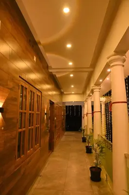a hallway with columns and plants in a building at Eden Spot in Marayoor
