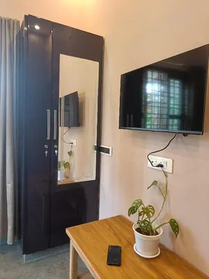 a room with a black door and a table with a plant at Eden Spot in Marayoor