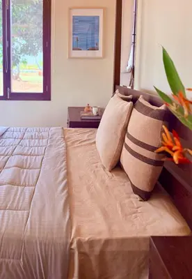 a bedroom with a bed with pillows and a window at Chandra - Journey back to you in Honganūr