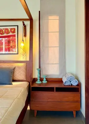 a bedroom with a bed and a wooden nightstand with a window at Chandra - Journey back to you in Honganūr