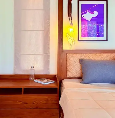 a bedroom with a bed and a nightstand with a table at Chandra - Journey back to you in Honganūr