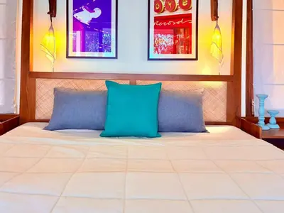 a bed with two blue pillows in a room at Chandra - Journey back to you in Honganūr