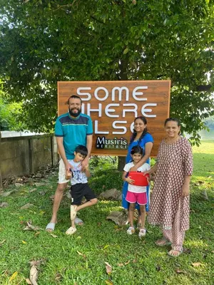 a group of people standing in front of a sign at Some where Else Musiris Heritage in Parūr