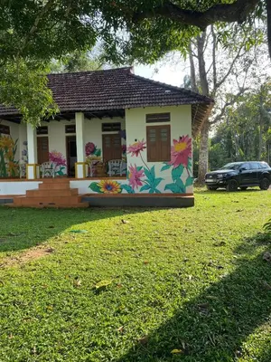a house with flowers painted on the side of it at Some where Else Musiris Heritage in Parūr