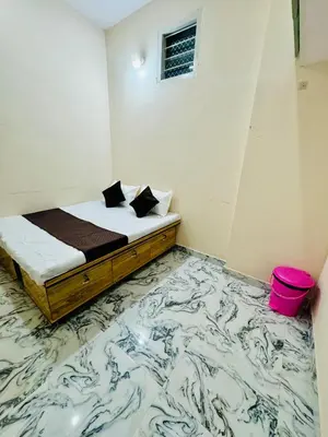 a bedroom with a bed with a marble floor at Flats in CITY Centre Next to Nexus Mall, 1km from bus stand in Mysore
