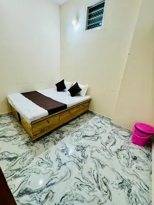 a bedroom with a bed with a marble floor at Flats in CITY Centre Next to Nexus Mall, 1km from bus stand in Mysore