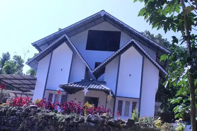 a white church with flowers in front of it at Orchid Homestay in Viripara