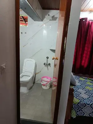 a bathroom with a toilet in a room at Ananya Homestay in Napoklu