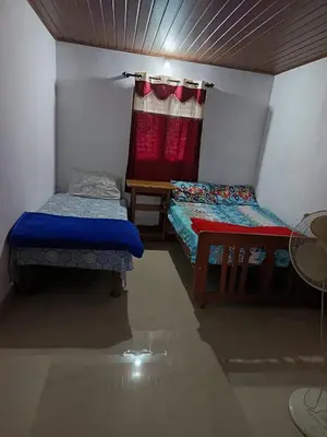 a small room with two beds and a window at Ananya Homestay in Napoklu