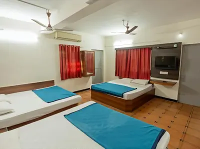 a bedroom with two beds and a flat screen tv at Royal Residency in Coimbatore