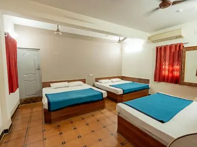 a room with two beds in it with red curtains at Royal Residency in Coimbatore