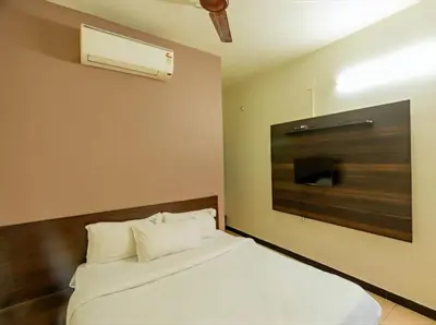 a bedroom with a white bed and a tv at Royal Residency in Coimbatore