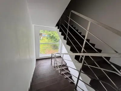a spiral staircase in a house with a window at Twilight Residency in Kizhake Chālakudi