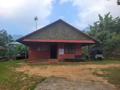 a small red house with a truck parked in front of it at Dream Acres Mudhouse in Vallikavungal