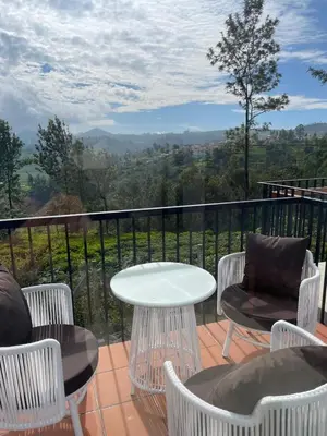 a table and chairs on a balcony with a view at Ozone The Misty Villa ooty ,Three Bed Room Luxury Private Jacuzzi Villa in Ketti