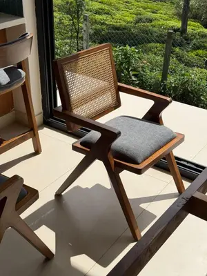 a wicker chair sitting on a porch with a window at Ozone The Misty Villa ooty ,Three Bed Room Luxury Private Jacuzzi Villa in Ketti