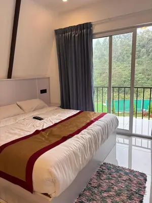 a bedroom with a bed and a large window at Bethel resorts in Kanthalloor