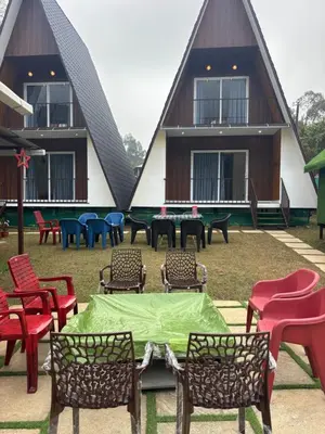 a group of chairs and tables in front of a house at Bethel resorts in Kanthalloor