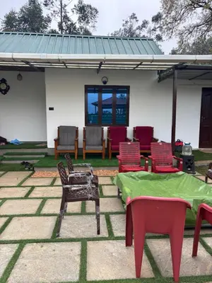 a group of chairs and tables in front of a building at Bethel resorts in Kanthalloor