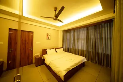 a bedroom with a bed with a ceiling fan at Spezio Luxurious Apartments in Perintalmanna