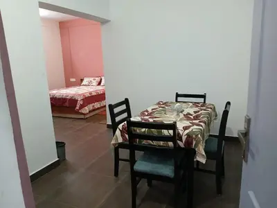 a dining room with a table and chairs and a bed at Willow Nest Cottages in Vattavada